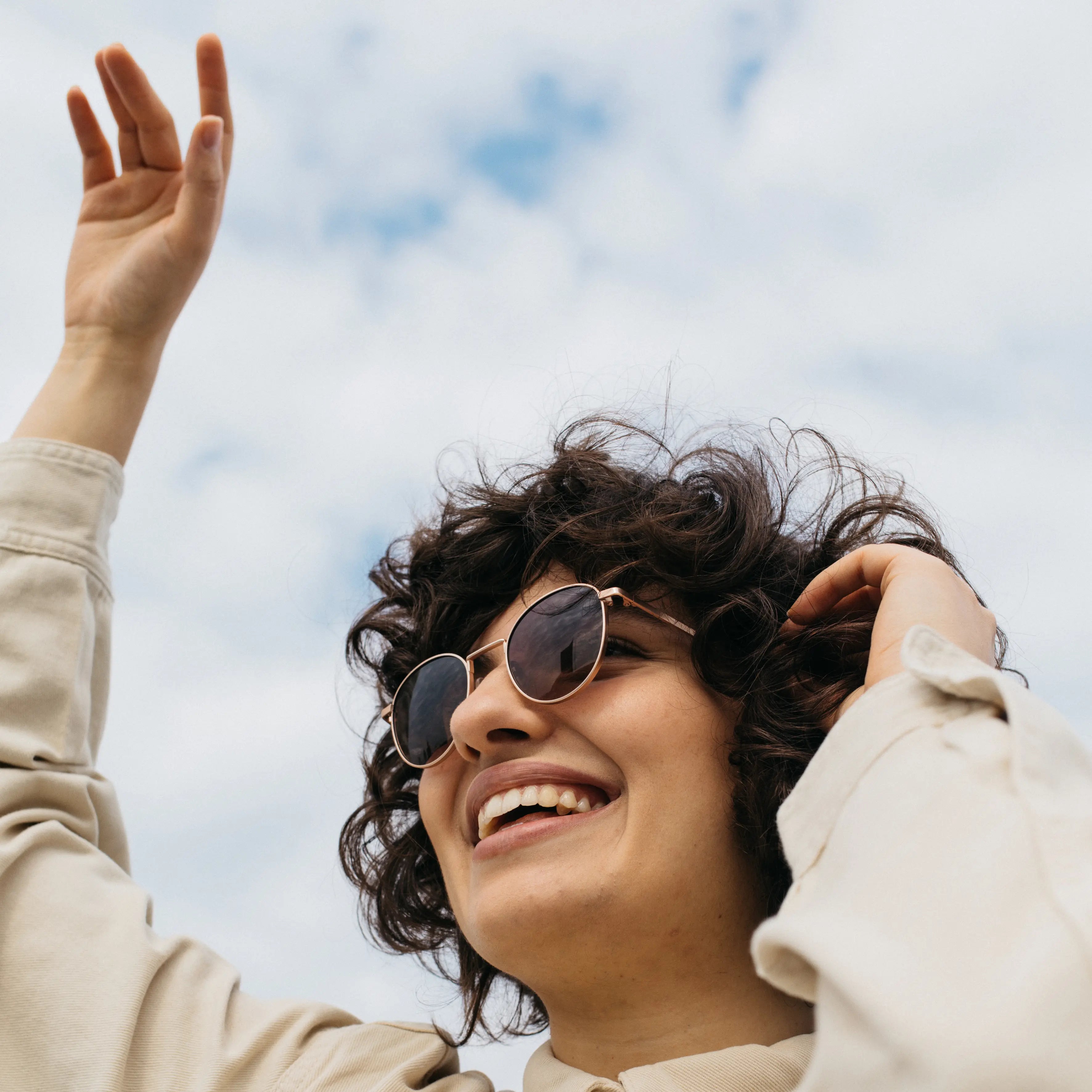 Eine junge Frau trägt eine nachhaltige, robuste Sonnenbrille von Take A Shot und lacht