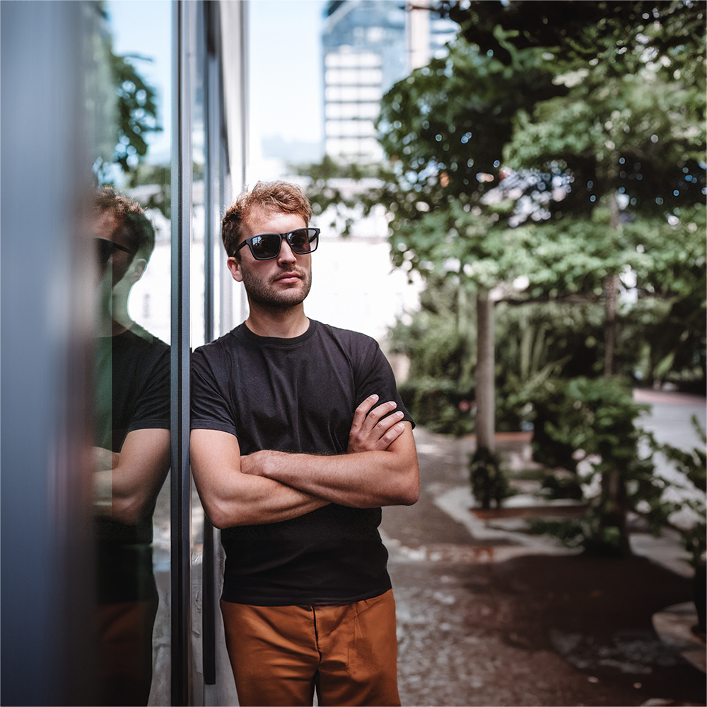 Junger Mann trägt eine nachhaltige Sonnenbrille in der Stadt